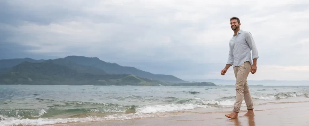 man-walking-on-beach-with-mountains-in-background